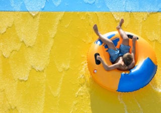 boy riding an inner tube on a water ride