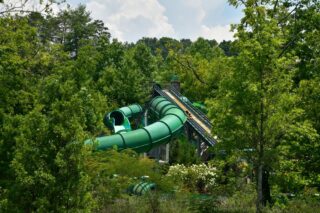 A side view of a large enclosed green waterslide.